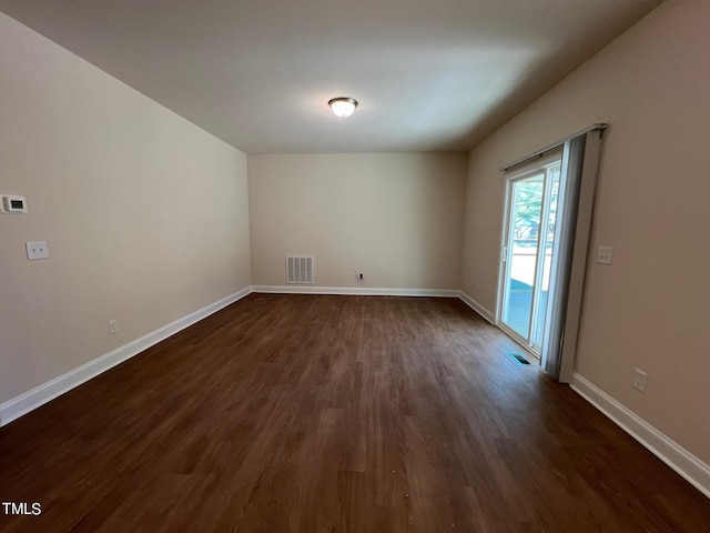 empty room with dark hardwood / wood-style flooring