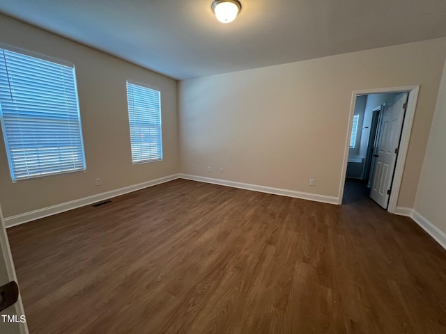 spare room with dark wood-type flooring