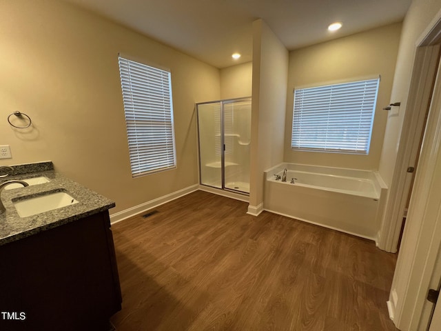 bathroom featuring plus walk in shower, vanity, and hardwood / wood-style flooring