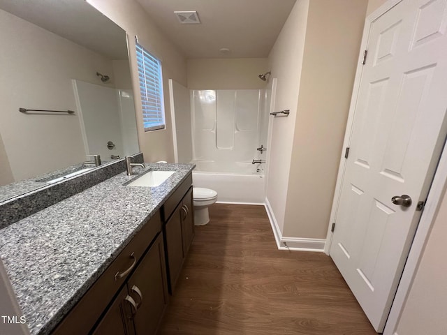 full bathroom with hardwood / wood-style floors, vanity, bathing tub / shower combination, and toilet