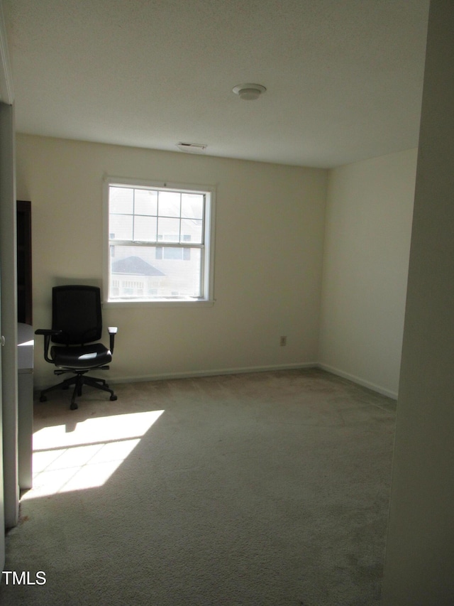 unfurnished office with baseboards and carpet flooring