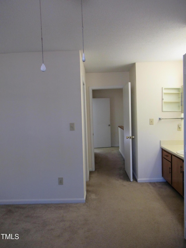 hall featuring light colored carpet and baseboards