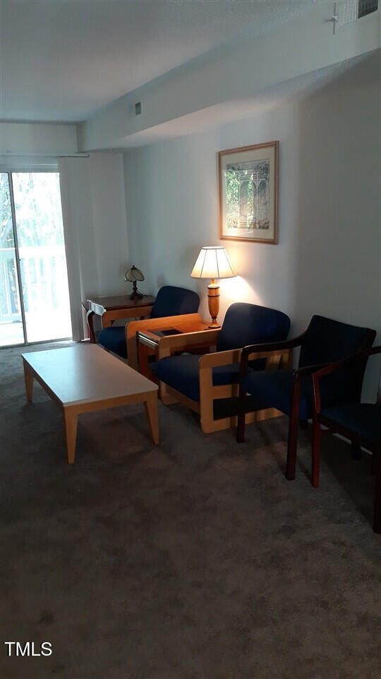 living area featuring carpet and visible vents