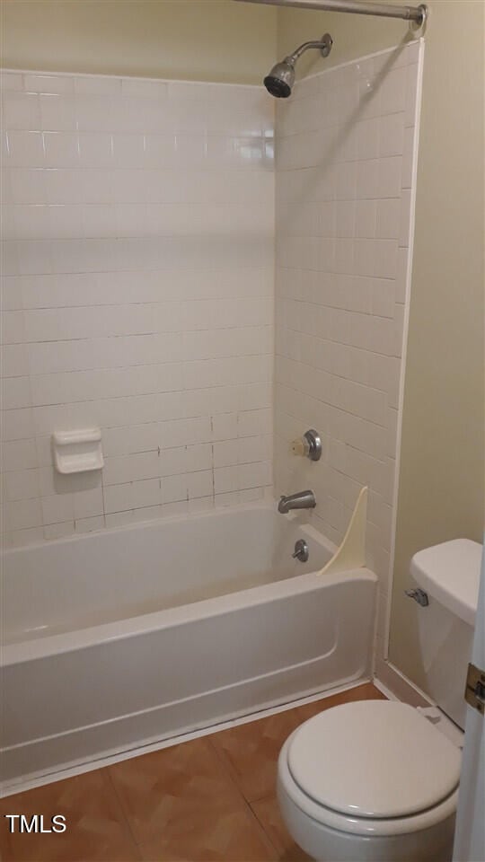 bathroom featuring bathtub / shower combination, toilet, and tile patterned floors