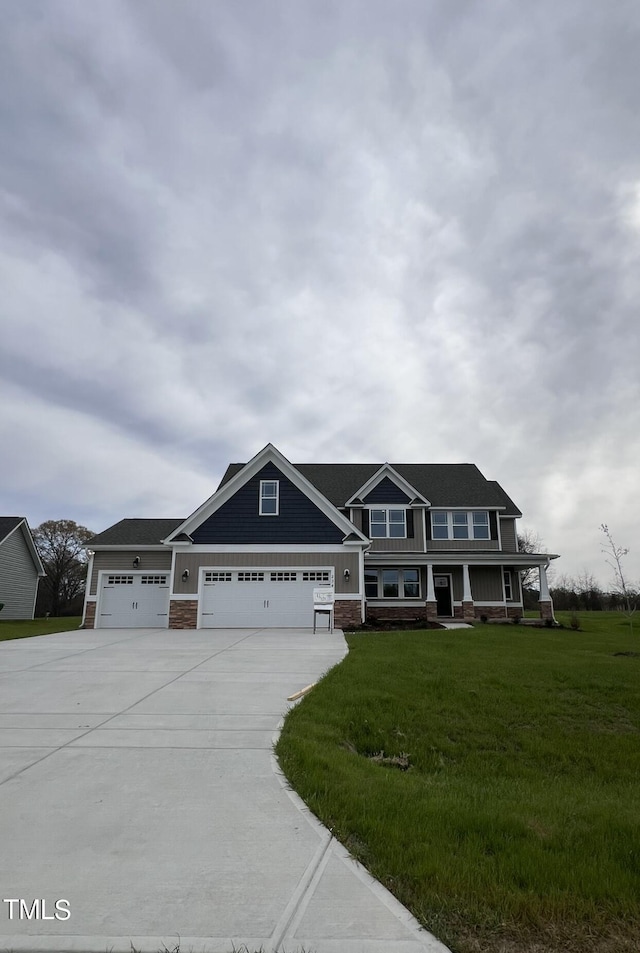 view of front facade with a garage, a porch, and a front lawn