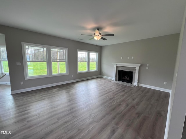 unfurnished living room with ceiling fan and dark hardwood / wood-style flooring