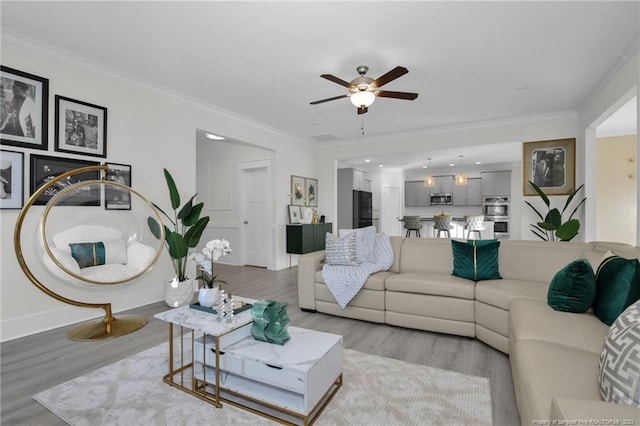 living room with ceiling fan, ornamental molding, and light hardwood / wood-style flooring