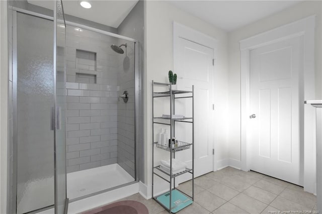 bathroom with a shower with shower door and tile patterned flooring