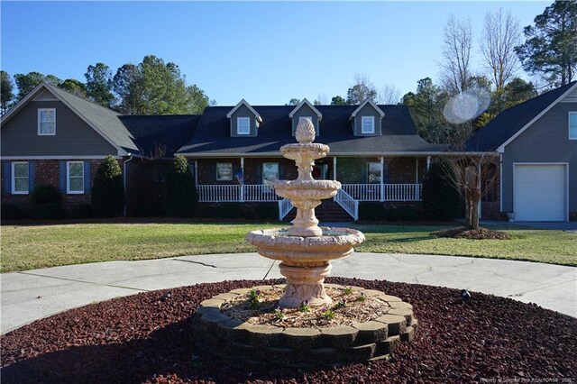 view of front of home with a porch, a garage, and a front lawn