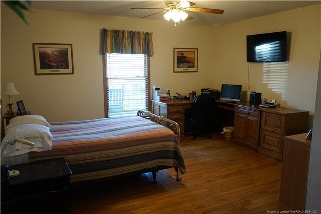 bedroom featuring a textured ceiling, wood-type flooring, and ceiling fan