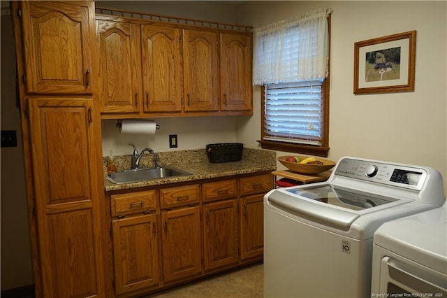 laundry room with cabinets, sink, and washer and clothes dryer