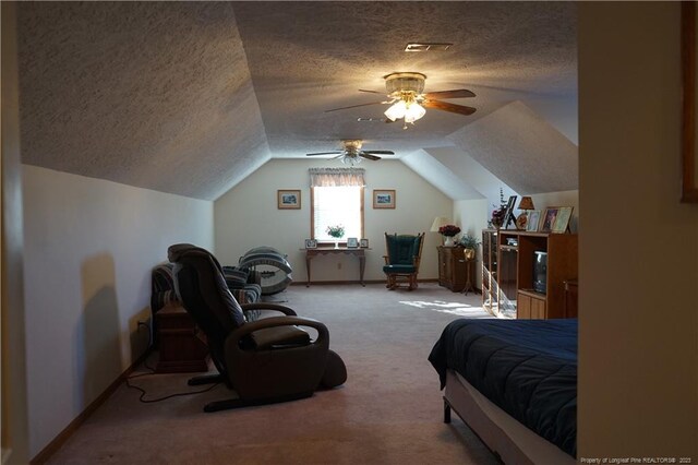 carpeted bedroom featuring ceiling fan, lofted ceiling, and a textured ceiling