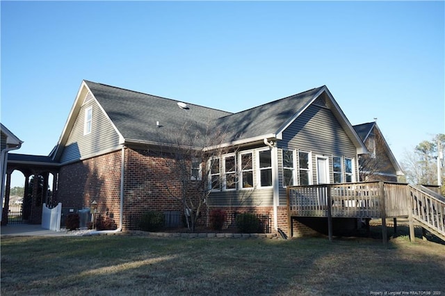 rear view of house with a lawn and a deck