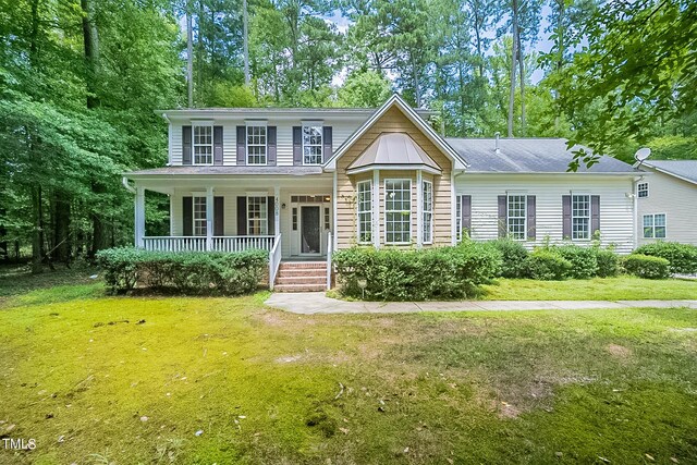 view of front of house with a front yard and a porch