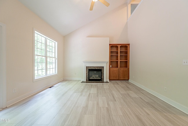 unfurnished living room with high vaulted ceiling and ceiling fan