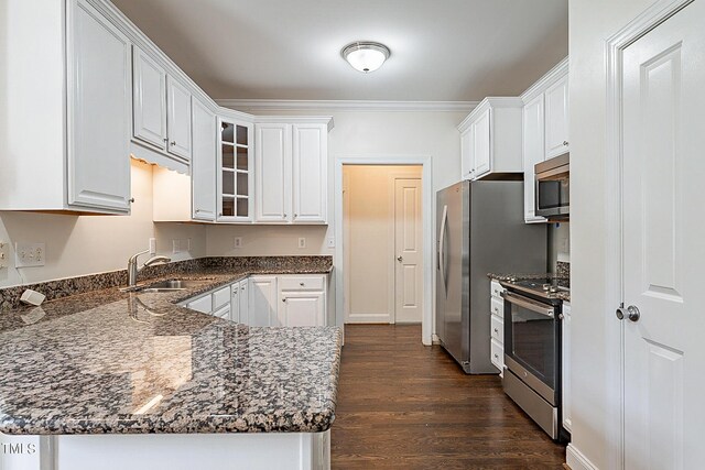 kitchen featuring dark hardwood / wood-style flooring, white cabinetry, ornamental molding, stainless steel appliances, and sink