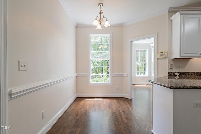 kitchen with a chandelier, white cabinets, hanging light fixtures, dark wood-type flooring, and ornamental molding