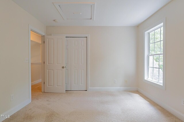 unfurnished bedroom with a closet and light colored carpet