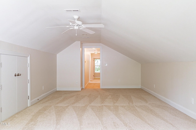 additional living space with ceiling fan, lofted ceiling, and light colored carpet