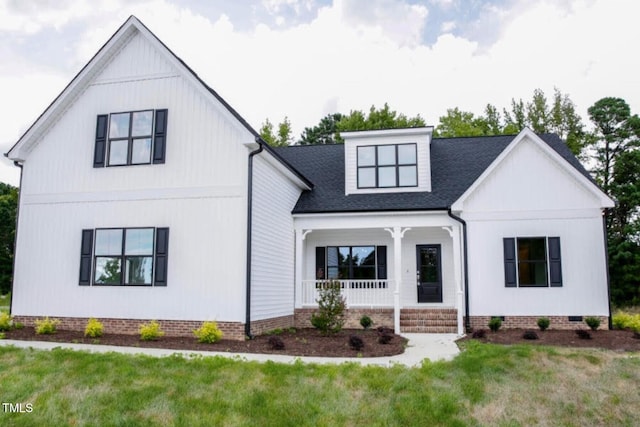 modern farmhouse featuring a porch and a front lawn