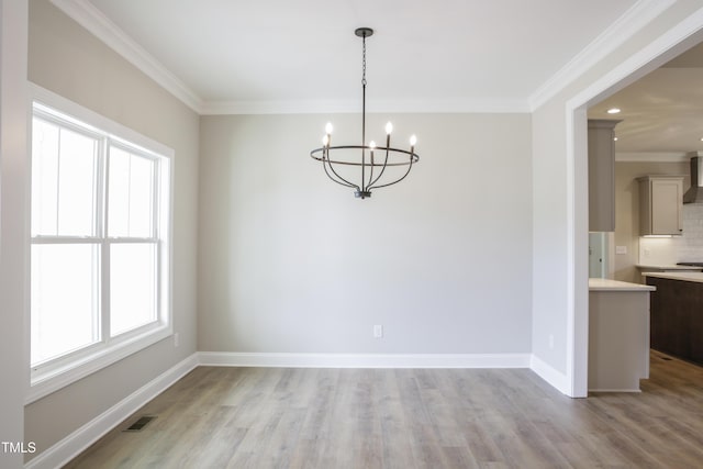 unfurnished dining area with a wealth of natural light, a chandelier, and light wood-type flooring