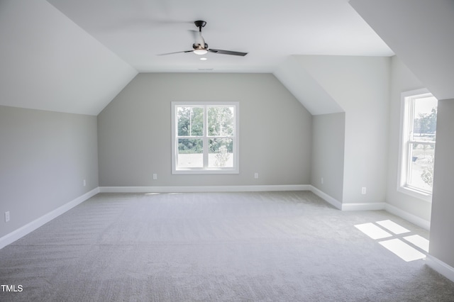 additional living space featuring light colored carpet, vaulted ceiling, and ceiling fan