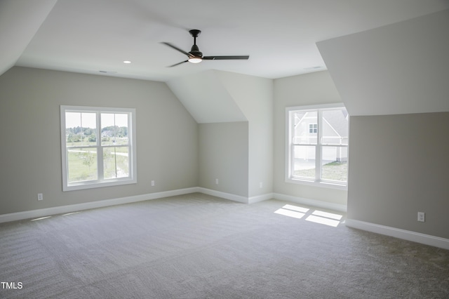 additional living space with light carpet, a wealth of natural light, and lofted ceiling