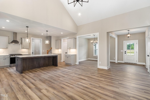 7327 Shawan Rd, Wendell, NC 27591 - kitchen with wall chimney range hood, stainless steel range, a chandelier, recessed lighting, and light wood-style floors