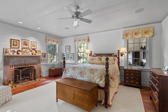 bedroom with hardwood / wood-style flooring, a fireplace, and ceiling fan