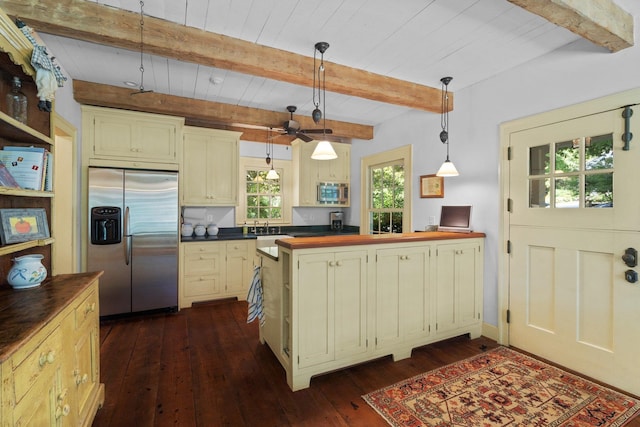 kitchen with beamed ceiling, appliances with stainless steel finishes, hanging light fixtures, and dark hardwood / wood-style floors