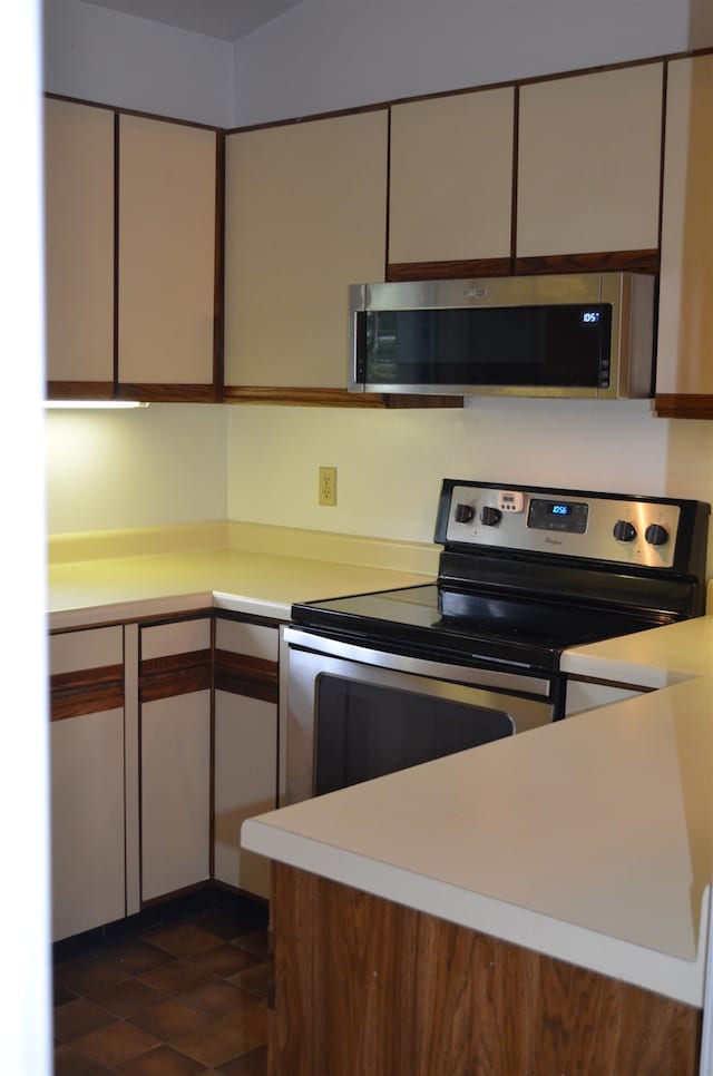 kitchen featuring dark tile patterned floors and appliances with stainless steel finishes