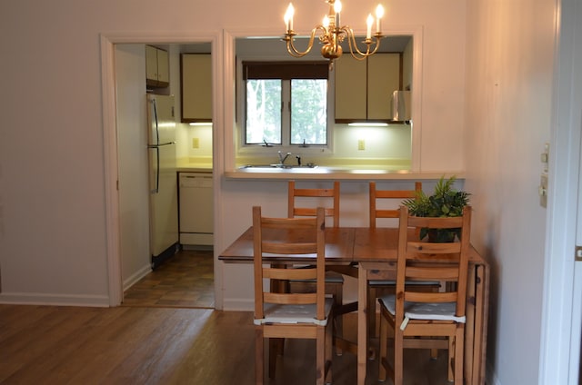 kitchen with dark hardwood / wood-style flooring, white appliances, sink, and an inviting chandelier