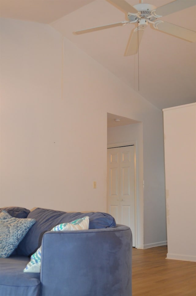 living room with wood-type flooring, ceiling fan, and vaulted ceiling