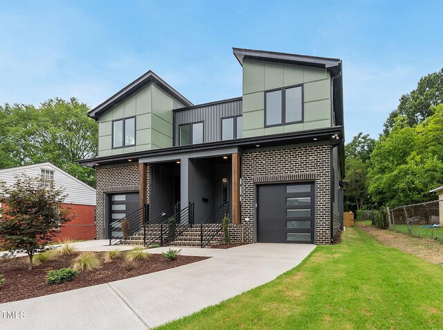 contemporary house featuring a garage and a front lawn