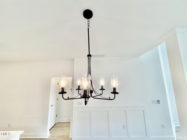 interior details featuring an inviting chandelier, baseboards, and wood finished floors