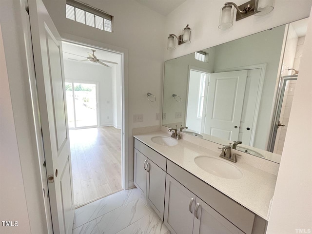 bathroom featuring marble finish floor, double vanity, and a sink