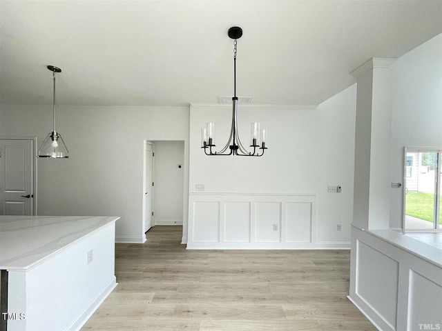 unfurnished dining area with a chandelier, visible vents, a decorative wall, and light wood-style flooring