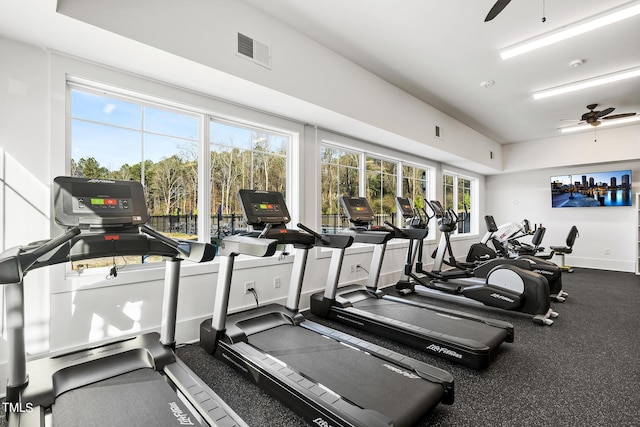 exercise room with ceiling fan, visible vents, and baseboards