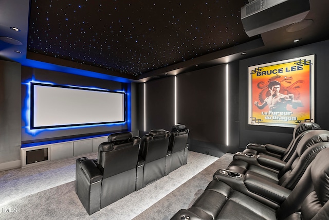 carpeted cinema room with a raised ceiling