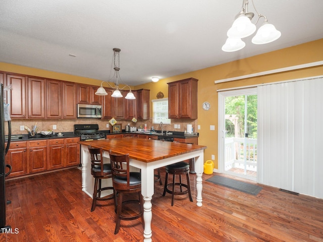 1209 Partington St, Wake Forest, NC 27587 - kitchen with black appliances, butcher block counters, dark wood-type flooring, and tasteful backsplash