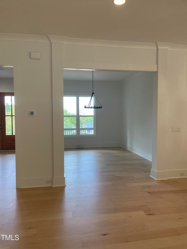 spare room with light hardwood / wood-style flooring and crown molding