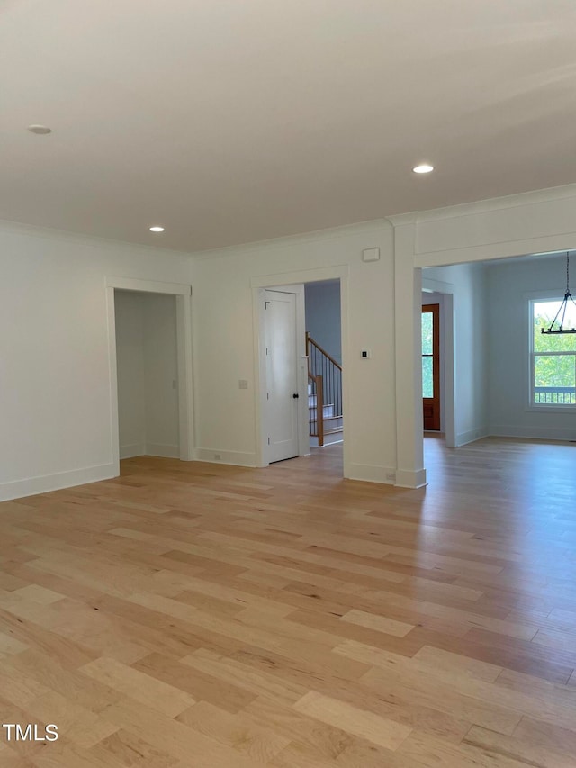 unfurnished room featuring light wood-type flooring and ornamental molding