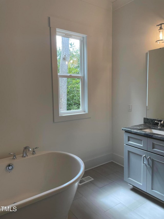 bathroom with vanity, tile patterned floors, and a bathtub