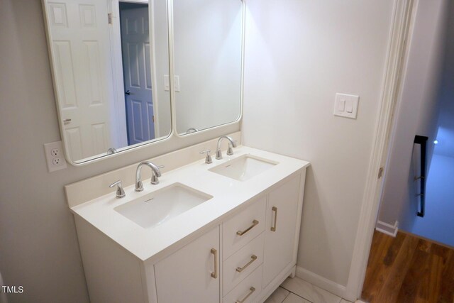 3404 Gemini Dr, Raleigh, NC 27604 - bathroom featuring baseboards, wood finished floors, a sink, and double vanity