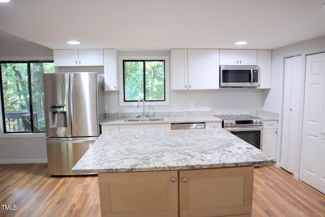 kitchen featuring sink, a kitchen island, light hardwood / wood-style flooring, white cabinetry, and stainless steel appliances