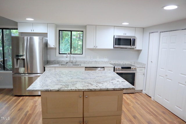 kitchen with light hardwood / wood-style flooring, appliances with stainless steel finishes, and white cabinetry