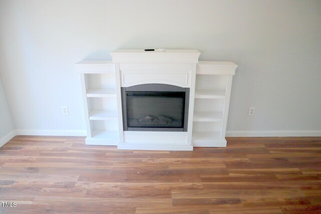 3404 Gemini Dr, Raleigh, NC 27604 - interior details featuring a glass covered fireplace, wood finished floors, and baseboards