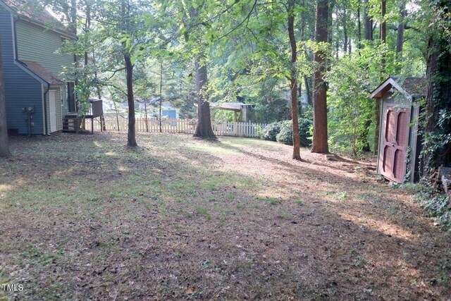 3404 Gemini Dr, Raleigh, NC 27604 - view of yard featuring fence, an outbuilding, and a shed
