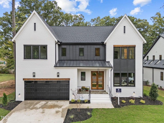 modern farmhouse featuring a front lawn and a garage