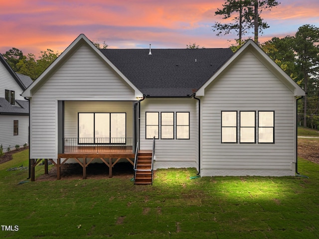 back house at dusk featuring a yard